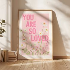 a pink poster with daisies and the words, you are so loved on it