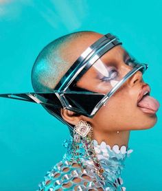 a woman sticking her tongue out while wearing futuristic garb