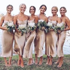 the bridesmaids are all wearing gold dresses and holding bouquets in their hands