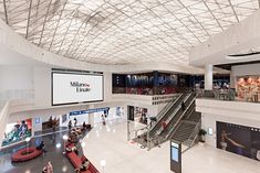 an overhead view of a mall with people walking and riding on escalators in the background