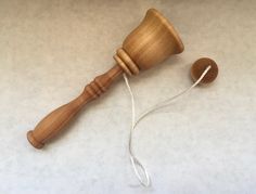 a wooden mallet with a string attached to it on a white tableclothed surface