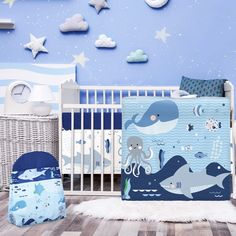 a baby crib bedding set with blue and white wallpaper, stars and clouds