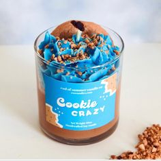 a cookie in a glass with blue frosting and sprinkles on top