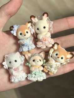 small stuffed animals are sitting on someone's hand in wedding attires and dresses