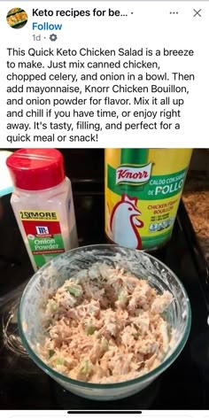 a glass bowl filled with chicken salad on top of a black counter next to two bottles of ketchup