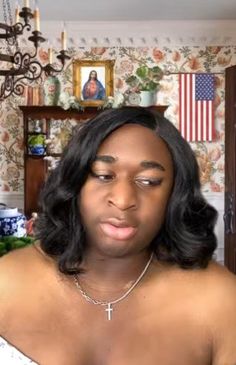 a woman in a white top is staring at the camera with an american flag on the wall behind her