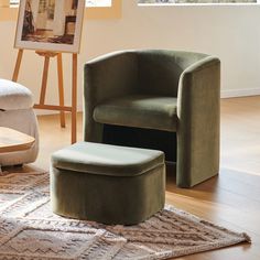 a green chair and foot stool in a room with hardwood floors, rugs and artwork