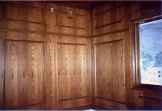 wood paneling in the corner of a room with a window and windowsills