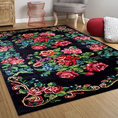 a black rug with colorful flowers on it in a living room next to a chair