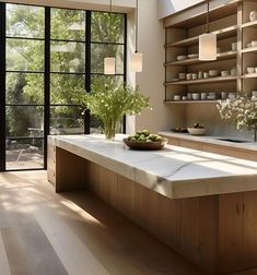 a kitchen with wooden cabinets and white counter tops next to an open door that leads to a patio