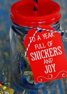 a jar filled with candy and a red tag that says to a year full of snickkers and joy