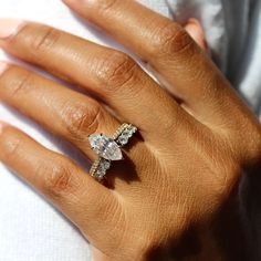 a woman's hand with a diamond ring on her left hand and an engagement ring on her right hand