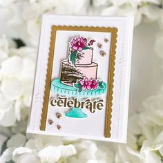 a close up of a card with flowers on it and a cake in the middle