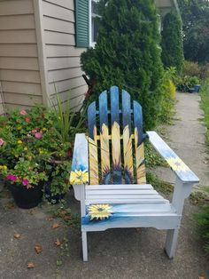 a painted wooden chair sitting in front of a house