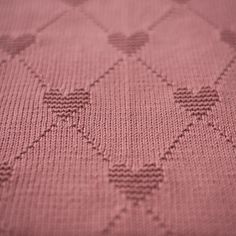 a close up view of a pink blanket with hearts on the bottom and back side