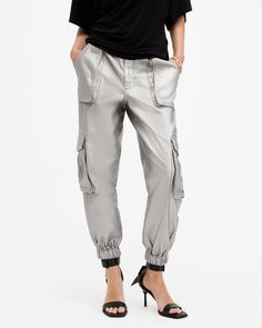 Cargo pants are so 90s, and we love it. Add a pair to your rotation - these are the Freda. Crafted from a metallic coated fabric and shaped to a regular silhouette with a tapered, cuffed leg. Pocket detailing on the legs completes the laidback aesthetic.  These pants are designed to a regular fit High-rise Zip closure Two front pockets Two side pockets Elasticated cuffs Tapered slim leg Allsaints Casual Bottoms For Fall, Silver Straight Leg Casual Pants, Allsaints Casual Fall Bottoms, Casual Silver Straight Leg Pants, Casual Metallic Bottoms With Pockets, Silver Casual Bottoms For Fall, Casual Silver Bottoms For Fall, Allsaints Casual Spring Pants, Metallic Bottoms With Pockets For Fall