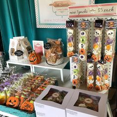 there is a table with halloween treats and candies for sale at the store,