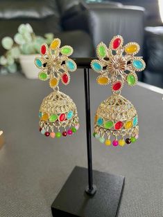 Elevate your style with our stunning duo pack featuring two unique designs.  ** Multistone Jhumkas** bring a traditional flair with vibrant stones, perfect for festive occasions or cultural outfits.   ** Gold Plated Red Stone Earrings these pieces add a bold pop of color and sophistication to any look.  Multicolor Jhumkas Length - 5.5 Cm ; Width - 2.3 Cm Redstone Earrings Length - 3.8 Cm ; W - 1.8 Cm Multicolor Metal Chandbali Earrings, Multicolor Jhumkas For Diwali, Multicolor Metal Earrings For Festivals, Traditional Multicolor Metal Earrings, Handmade Multicolor Fusion Jhumkas, Multicolor Metal Chandbali Danglers, Multicolor Chandbali Earrings For Festival, Fusion Style Multicolor Metal Earrings, Festive Multicolor Metal Earrings