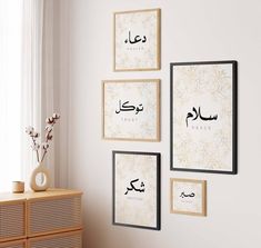 three framed pictures hang on the wall above a dresser in a room with white walls