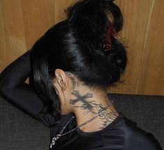 a woman with tattoos on her neck and back