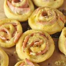 many small pastries with ham and cheese on them