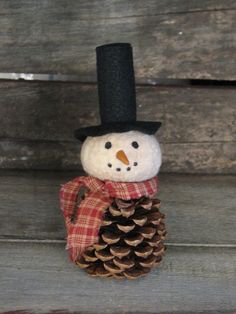 a snowman made out of pine cones with a top hat