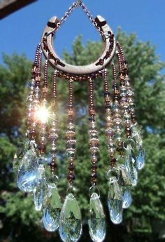 a wind chime hanging from a wooden pole with lots of beads and stones on it