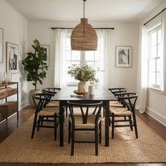 a dining room table with chairs and a potted plant in the center on top of it