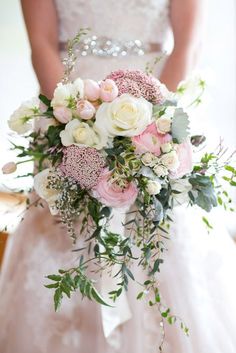 a bridal holding a bouquet of pink and white flowers