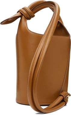 Buffed leather top handle bag in brown. · Rolled carry handle · Knotted accent at shoulder strap · Logo hardware at face · Bumper studs at base · Press-stud closure at throat · Zip and patch pocket at interior · Cotton twill lining · H9.5 x W10 x D7.5 · Total height: 14 Supplier color: Light brown Brown Calf Leather Top Handle Bucket Bag, Brown Calf Leather Satchel With Top Carry Handle, Brown Calf Leather Shoulder Bag With Handles, Brown Calf Leather Bucket Bag For Work, Brown Calf Leather Bag With Handles, Brown Calf Leather Shoulder Bag With Detachable Handle, Brown Calf Leather Bucket Bag For Office, Brown Calf Leather Satchel With Adjustable Strap, Brown Calf Leather Bag With Adjustable Strap