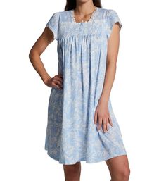 Soft, lightweight nightgown features lovely finishing touches and a classic pattern. Silkyknit fabric feels remarkably soft and light to the touch. Square neckline has a border of floral lace applique. Partial button closure at neck is topped off with a small bow and secures with 4 buttons. Smocking over bust is accented with shiny thread. Short cap sleeves with ruching at top and picot trim at openings. Hem and back of neck are trimmed with picot. Above-the-knee design. Pullover styling. Brande Elegant Light Blue Sleepwear For Loungewear, Comfortable Blue Dresses For Loungewear, Blue Relaxed Fit Sleepwear For Overnight, Blue Relaxed Fit Nightgown For Bedtime, Light Blue Relaxed Fit Sleepwear, Light Blue Cotton Nightgown For Loungewear, Blue Spring Nightgown For Overnight, Blue Nightgown For Spring, Casual Blue Nightgown For Relaxation