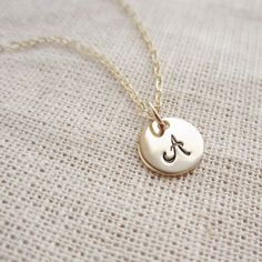 Cursive gold initial necklace personalized by KGarnerDesigns Delicate Personalized Pendant Charm Necklaces, Delicate Personalized Pendant Charm Necklace, Dainty Hand Stamped Round Disc Necklaces, Dainty Hand Stamped Round Disc Necklace, Everyday Monogram Initial Necklace, Simple Initial Pendant Charm Necklaces, Everyday Gold Charm Necklace With Custom Name, Minimalist Round Hand Stamped Charm Necklaces, Dainty Hand Stamped Necklaces For Personalized Gift