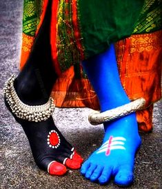 two feet with blue and red painted on them, one has a beaded ankle