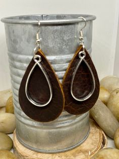 "Handmade, genuine leather charm teardrop earrings measuring Aprox 2\" long in a variety of colors and metal color options either tools or silver. Available options are: Weathered brown leather teardrop earrings with coordinating charm in silver or gold Camel, cognac teardrop earrings with coordinating charm in silver or gold Hunter green, Forrest green teardrop earrings with coordinating charm in silver or gold Teardrop earrings, gold earrings, silver earrings, fall earrings, camel earrings, co Everyday Brown Metal Jewelry, Everyday Brown Metal Earrings, Nickel Free Drop Earrings For Everyday Use, Leather Dangle Earrings With Ear Wire, Adjustable Brown Teardrop Jewelry, Everyday Hand Tooled Leather Jewelry, Brown Teardrop Jewelry For Everyday Wear, Brown Teardrop Jewelry For Everyday, Everyday Hand-tooled Leather Jewelry