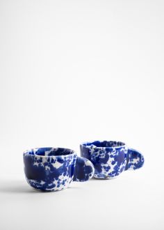 two blue and white cups sitting next to each other