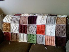 a crocheted blanket sitting on top of a couch