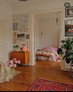 a living room filled with lots of furniture and flowers on top of a wooden floor