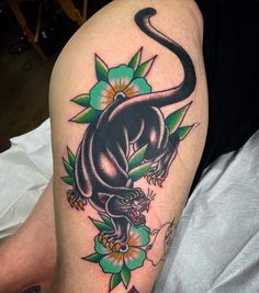 a black panther with flowers on its thigh