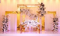 an elegant wedding setup with white flowers and gold chairs