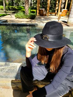 Introducing the Venice Hat, a timeless classic fedora adorned with a sleek black leather band and our iconic sun logo. This versatile accessory exudes sophistication and effortless style, making it perfect for any occasion. Whether you're exploring the canals of Venice or attending a casual city outing, this hat seamlessly complements your outfit and ensures you make a fashionable statement. Luxury Black Casual Sun Hat, Luxury Casual Black Fedora, Black Fedora Sun Hat, One Size Fits Most, Luxury Black Fedora, Luxury Elegant Fedora-style Panama Hat, Sun Logo, Gold Sun, Black Hat, Timeless Classic