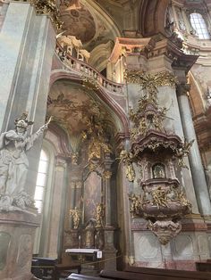 the interior of an old church with gold and white decorations