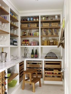 a kitchen with lots of wooden shelves filled with wine glasses and other items on top of them