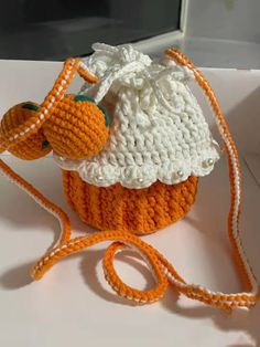 an orange and white crocheted bag with a bird on it's back