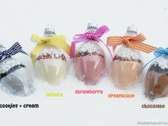 six glass ornaments with bows on them in the snow, all decorated to look like they are filled with marshmallows