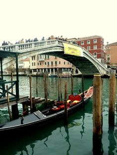 a gondola on the water in front of a bridge