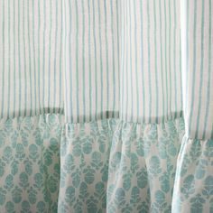 the curtains are lined up with blue and white striped material on top of each other