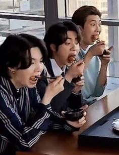 four people sitting at a table eating food