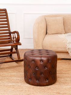 a brown leather ottoman sitting next to a rocking chair