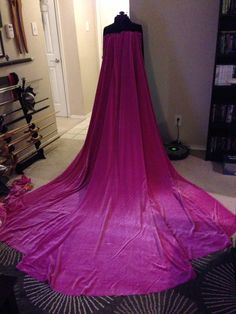 a purple dress is draped in front of a bookshelf