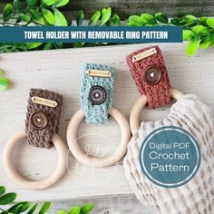 three crochet rings with wooden handles and buttons on them, sitting next to each other